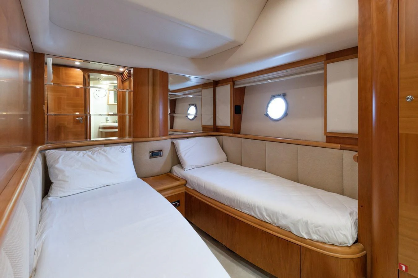 The guest cabin features twin beds with a warm wood finish and ample natural light from the porthole. aboard SENIOR S Yacht for Sale