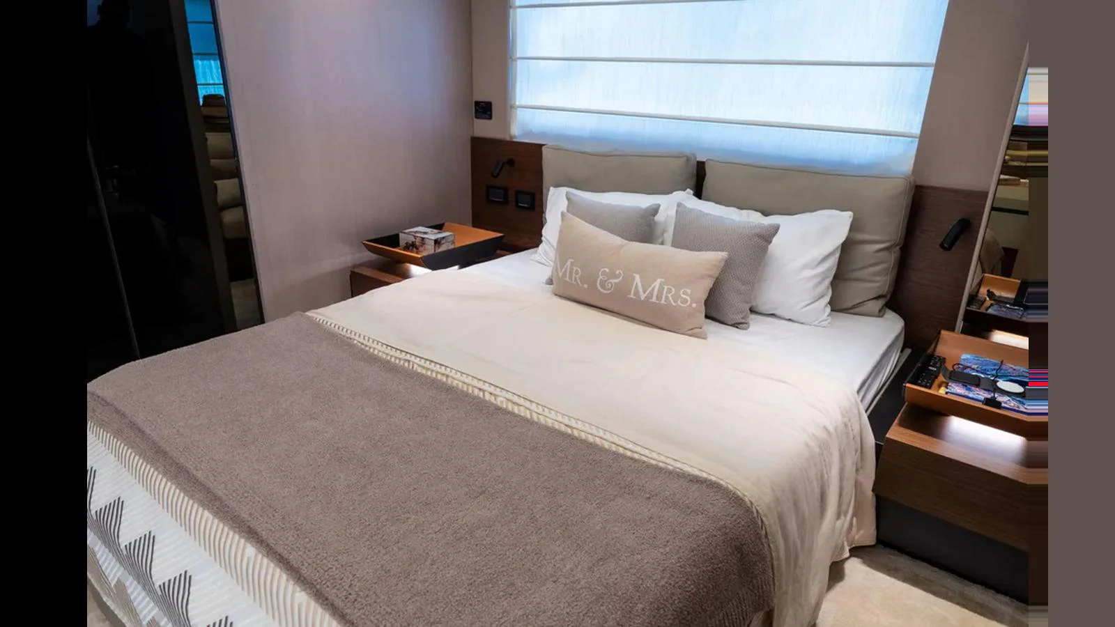 A cozy stateroom with a large bed adorned with a 'Mr. & Mrs.' pillow, creating a welcoming atmosphere. aboard AZIMUT S7 Yacht for Sale