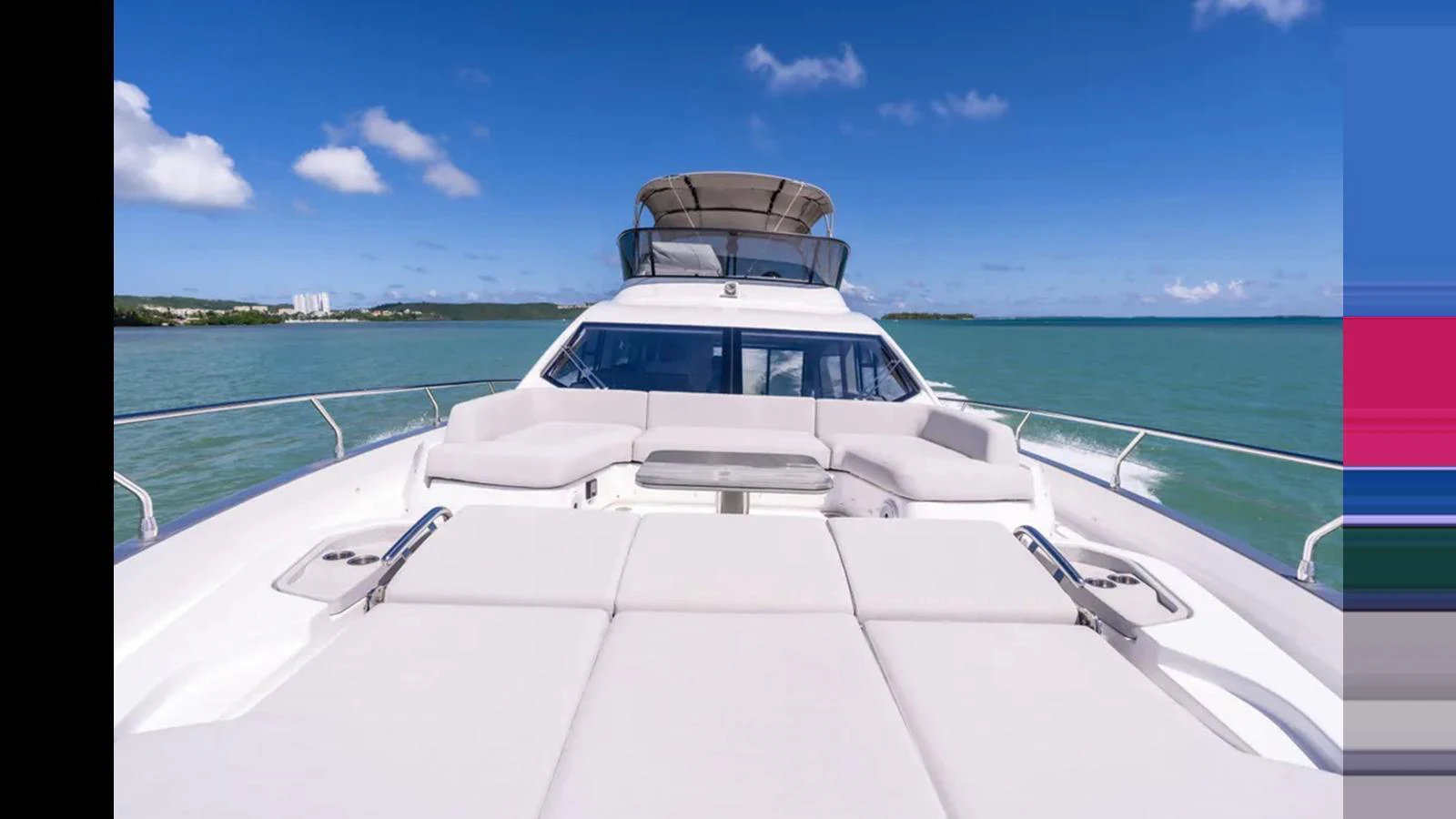 The yacht's foredeck offers a spacious sunbathing area with plush cushions, perfect for relaxation under the clear blue sky. aboard AZIMUT S7 Yacht for Sale