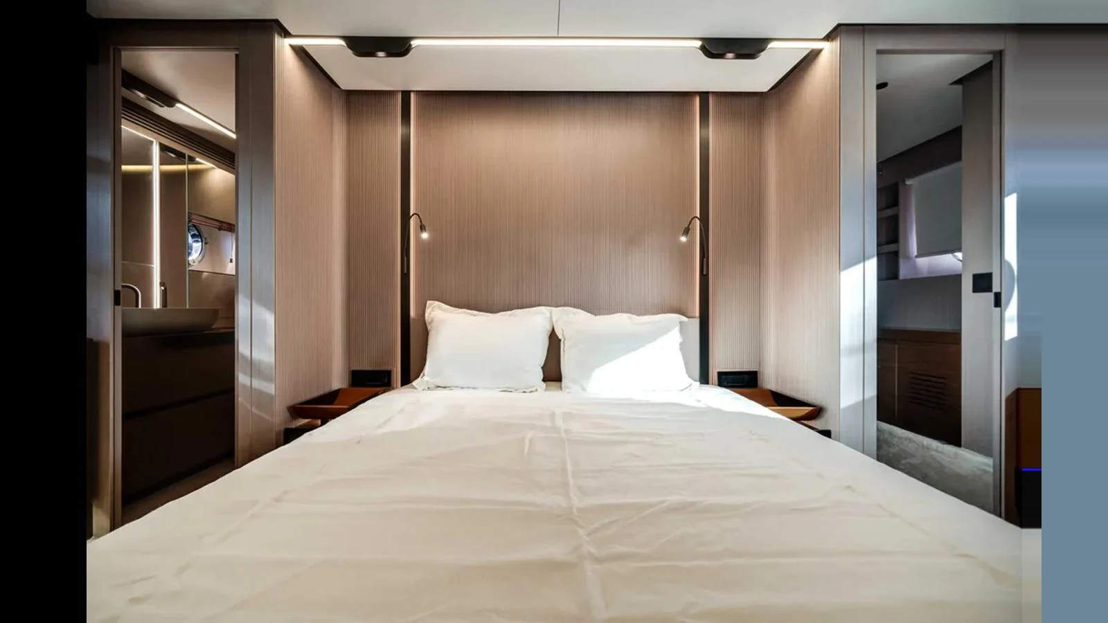 A luxurious stateroom featuring a plush double bed with modern lighting and sleek wooden finishes. aboard 2025 AZIMUT S8 Yacht for Sale