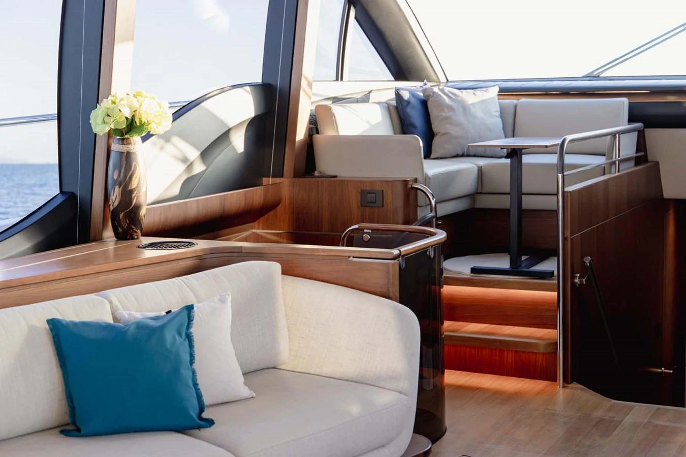 The yacht's salon features elegant seating with plush cushions and a stylish table, bathed in natural light. aboard CAMILLE Yacht for Sale