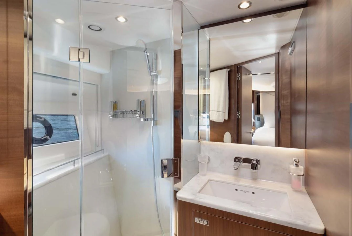 The yacht's bathroom features a modern shower and sleek vanity with ample lighting. aboard CAMILLE Yacht for Sale