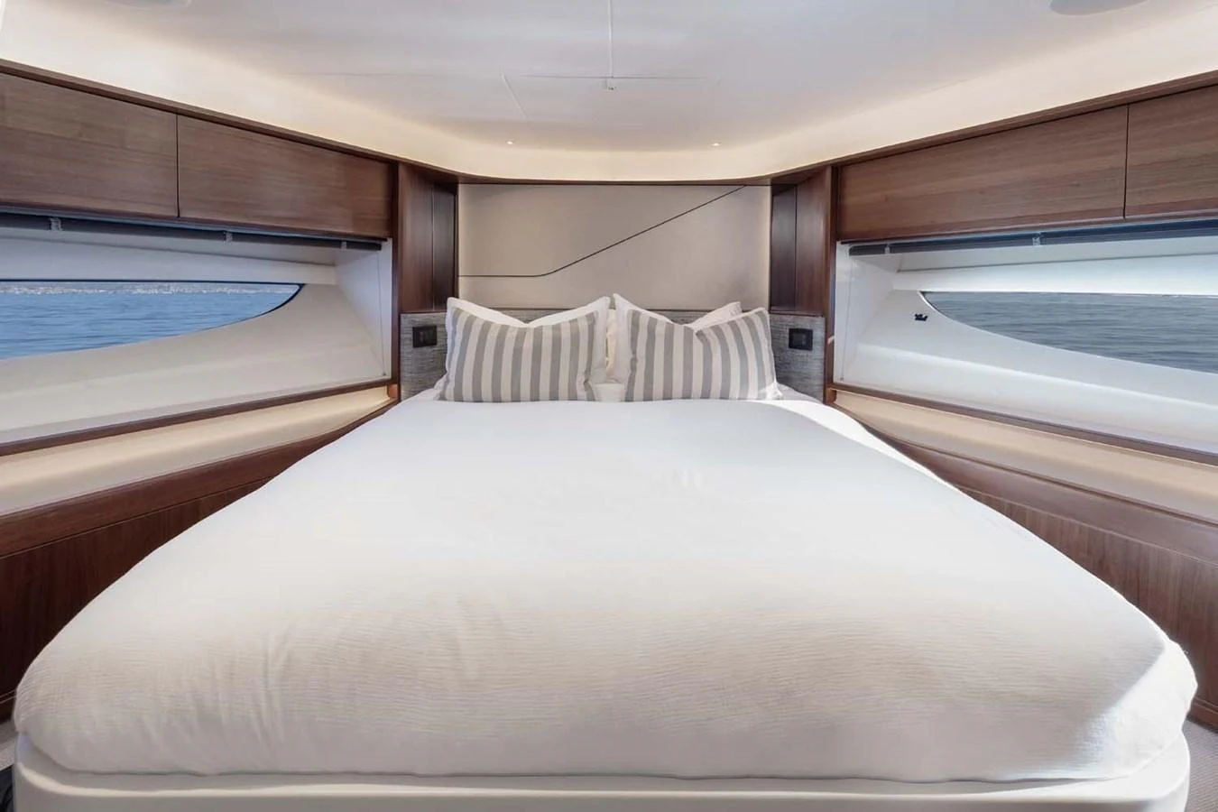 A luxurious stateroom featuring a large, comfortable bed with elegant bedding and ample natural light from the windows. aboard CAMILLE Yacht for Sale