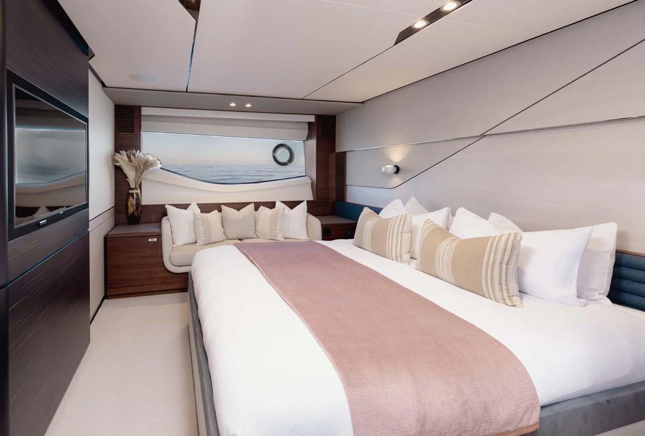 The stateroom features a luxurious bed with elegant decor and a scenic window view. aboard CAMILLE Yacht for Sale