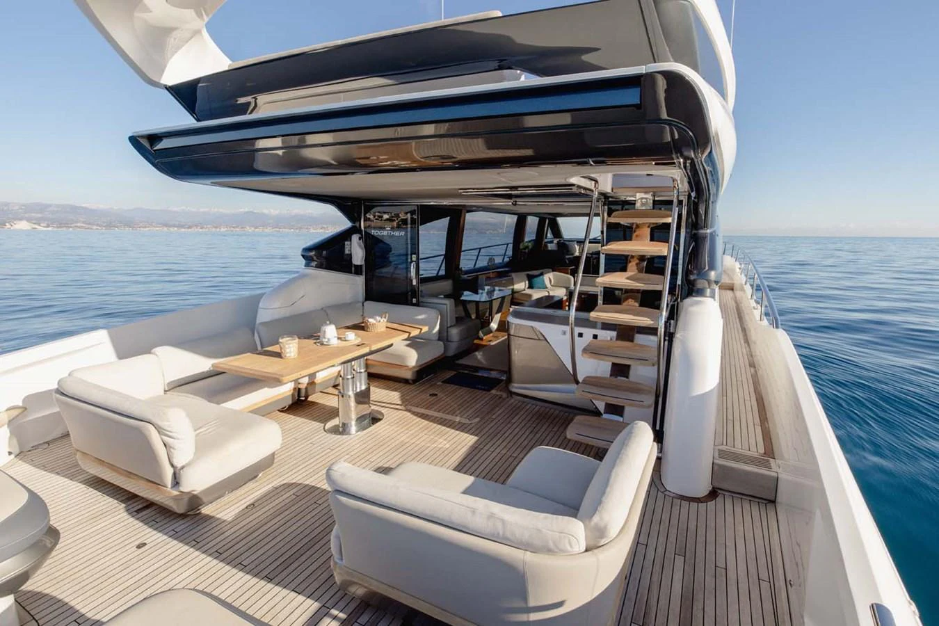 The aft deck features comfortable seating and a dining area, perfect for relaxing and enjoying meals outdoors. aboard CAMILLE Yacht for Sale