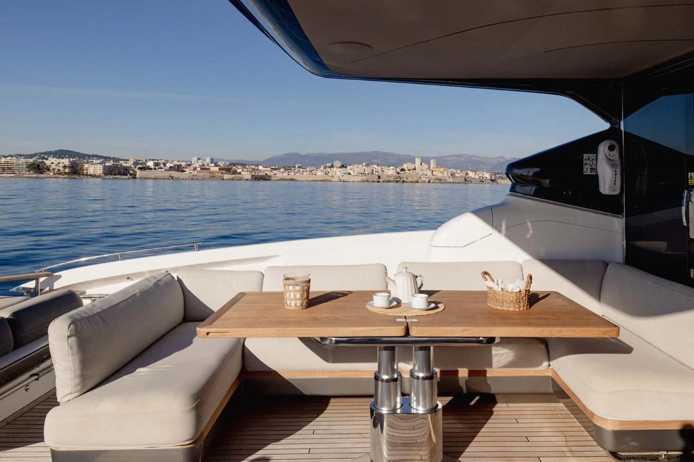 The aft deck features a comfortable seating area with a wooden table, perfect for enjoying meals with a view. aboard CAMILLE Yacht for Sale