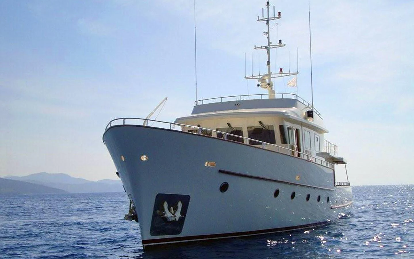 A sleek yacht cruising on calm waters under a clear sky. aboard XANAX Yacht for Sale