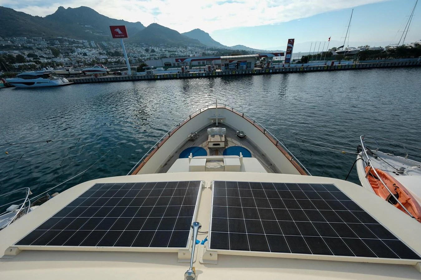 The yacht is docked at a marina with solar panels visible on the deck. aboard XANAX Yacht for Sale