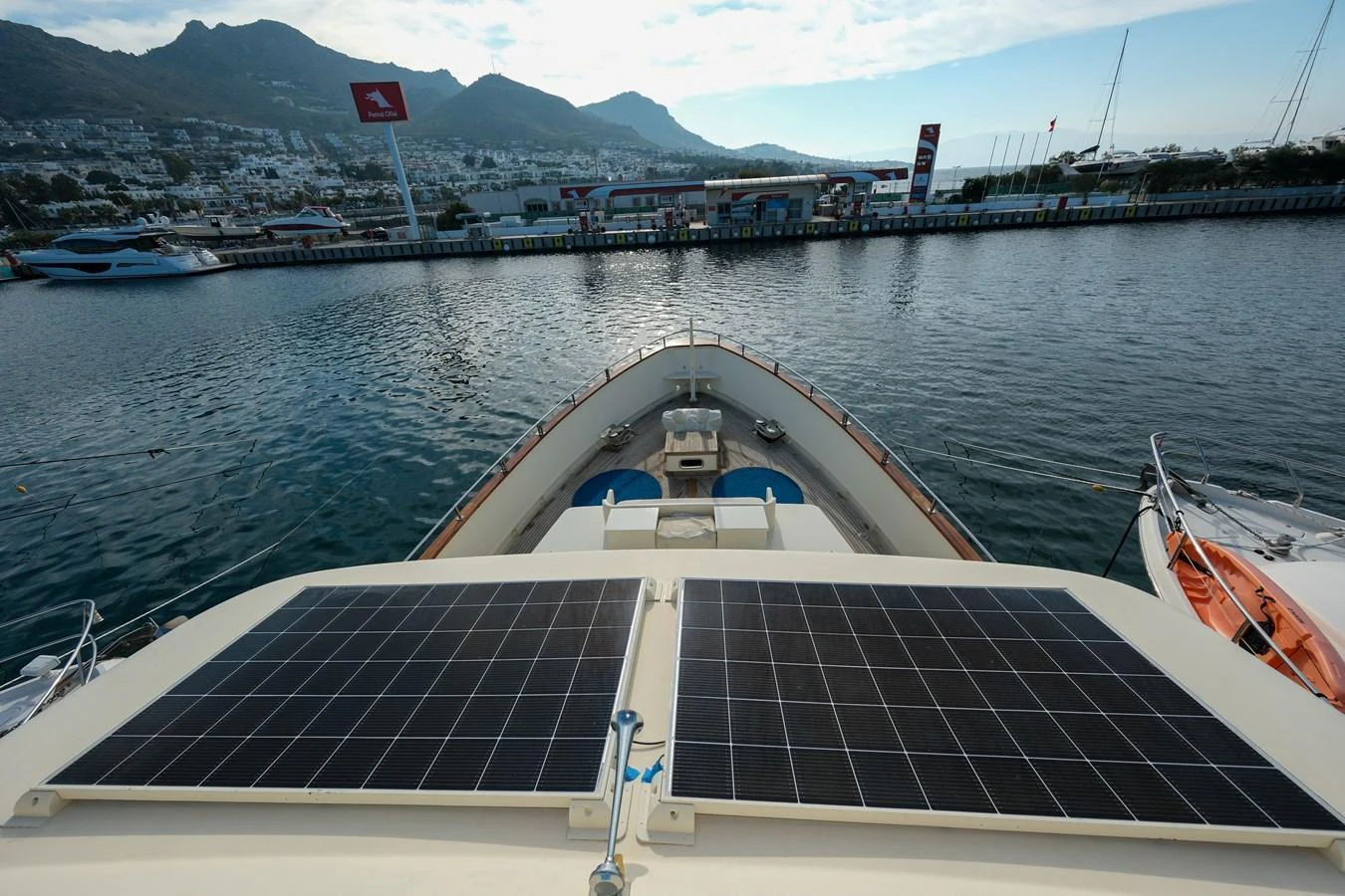 The yacht is docked at a marina with solar panels visible on the deck. aboard XANAX Yacht for Sale