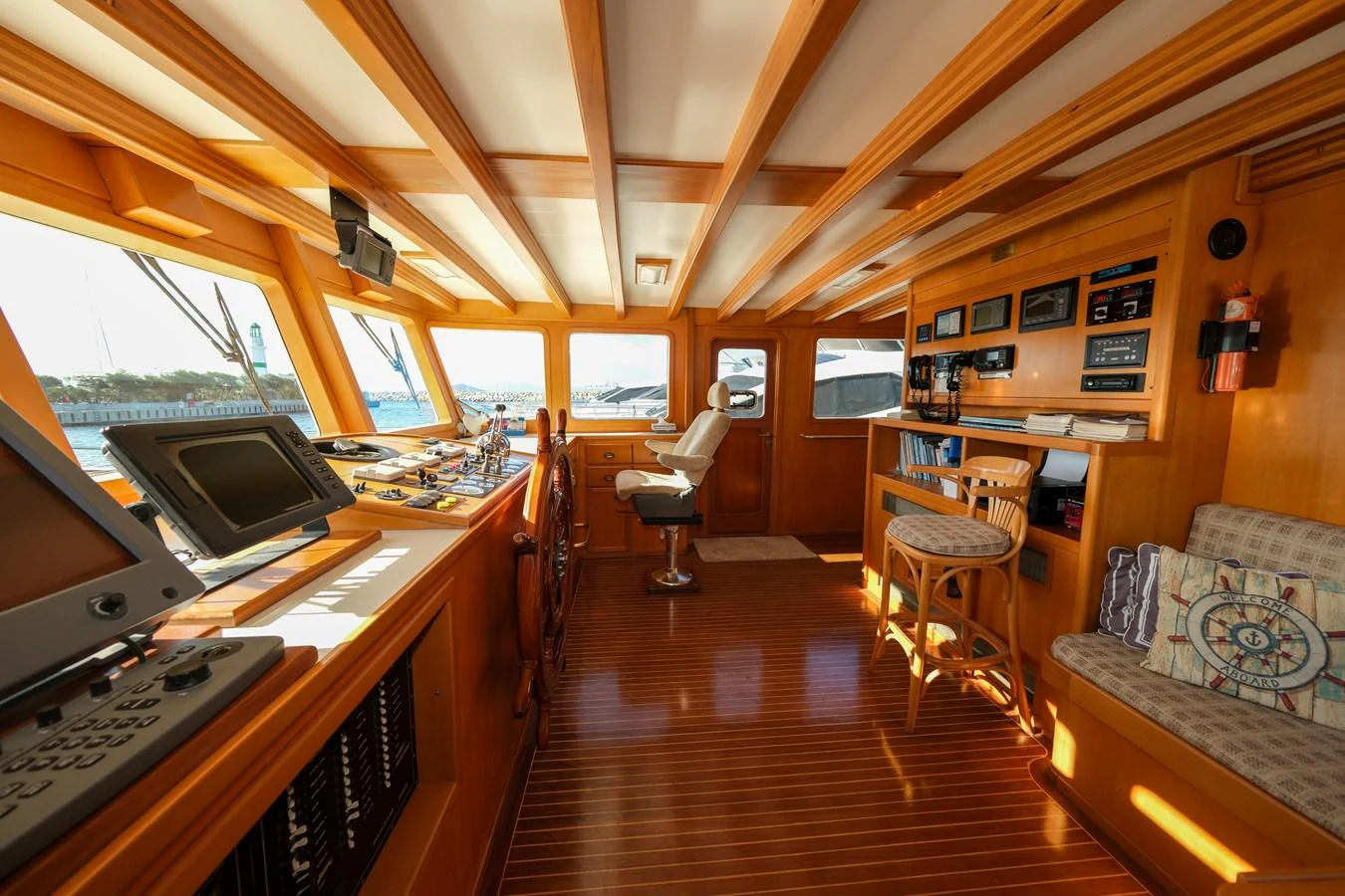 The helm station features a warm wooden interior with ample natural light and modern navigation equipment. aboard XANAX Yacht for Sale