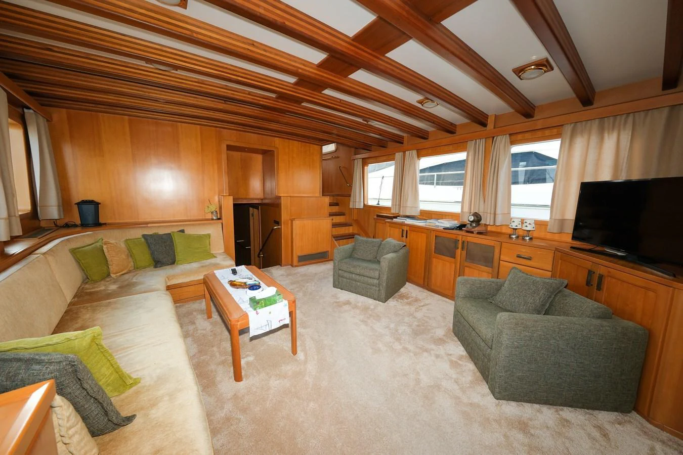 The salon features comfortable seating with a warm wooden finish and ample natural light. aboard XANAX Yacht for Sale