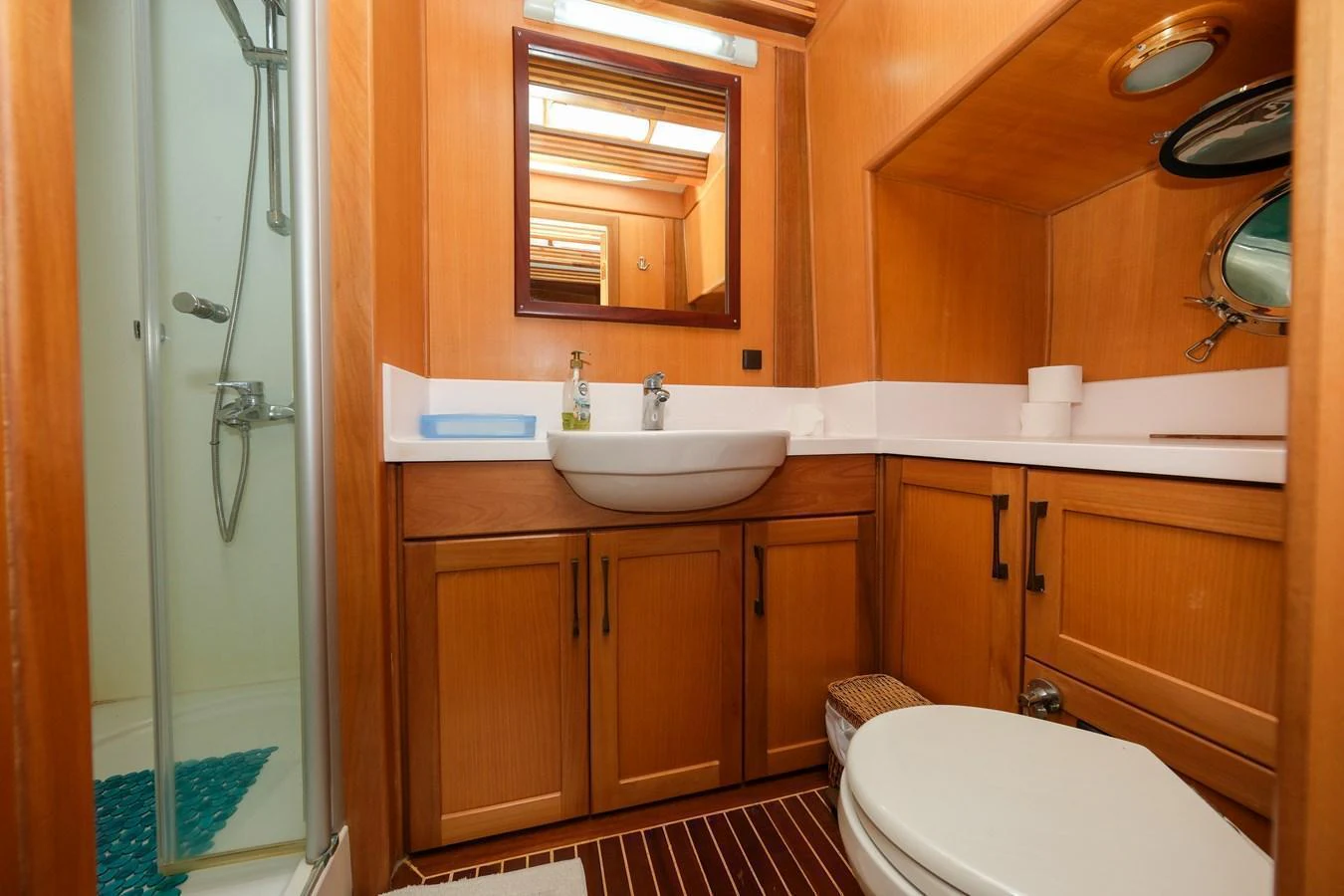 The yacht's bathroom features a sleek design with wooden cabinetry and modern fixtures. aboard XANAX Yacht for Sale