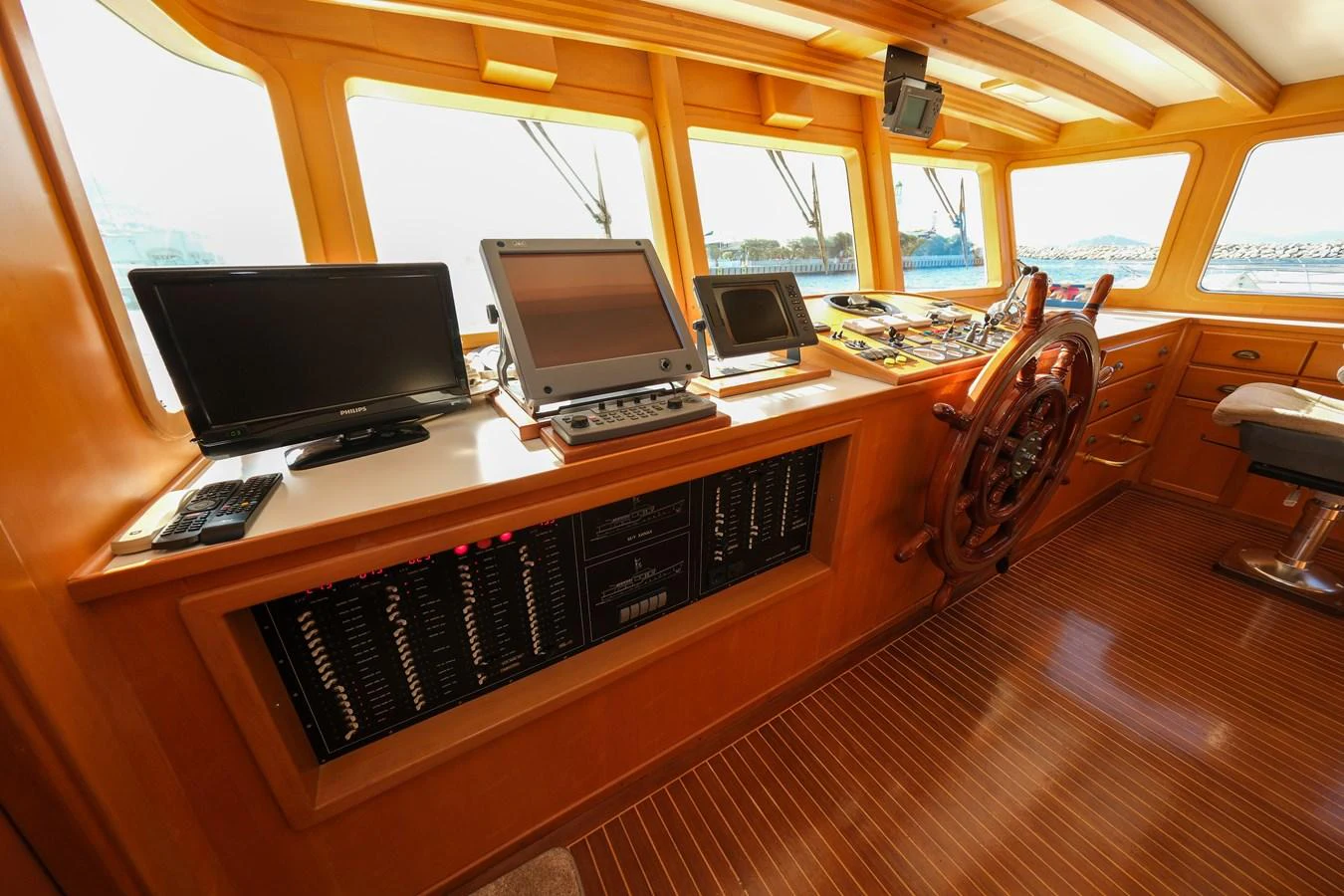 The helm station features advanced navigation equipment and a classic wooden steering wheel. aboard XANAX Yacht for Sale