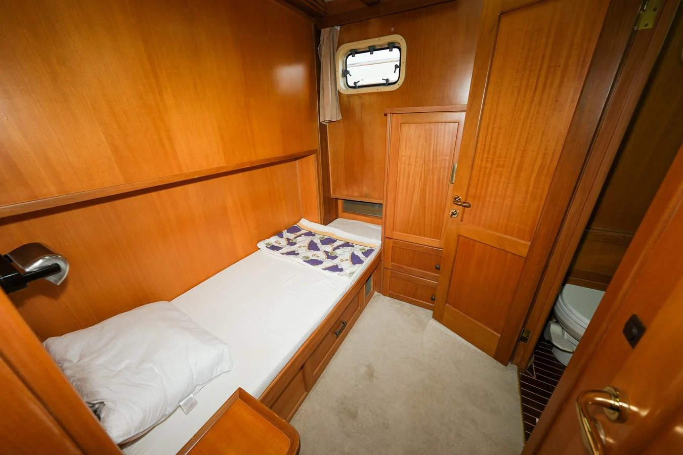 A cozy guest cabin featuring a single bed and warm wooden paneling. aboard XANAX Yacht for Sale
