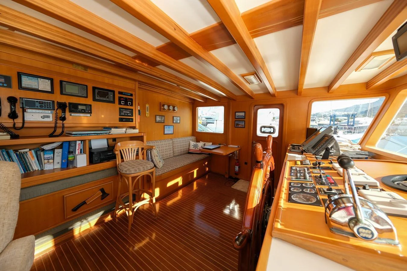 The helm station features a warm wooden interior with an array of navigational instruments and a comfortable seating area. aboard XANAX Yacht for Sale