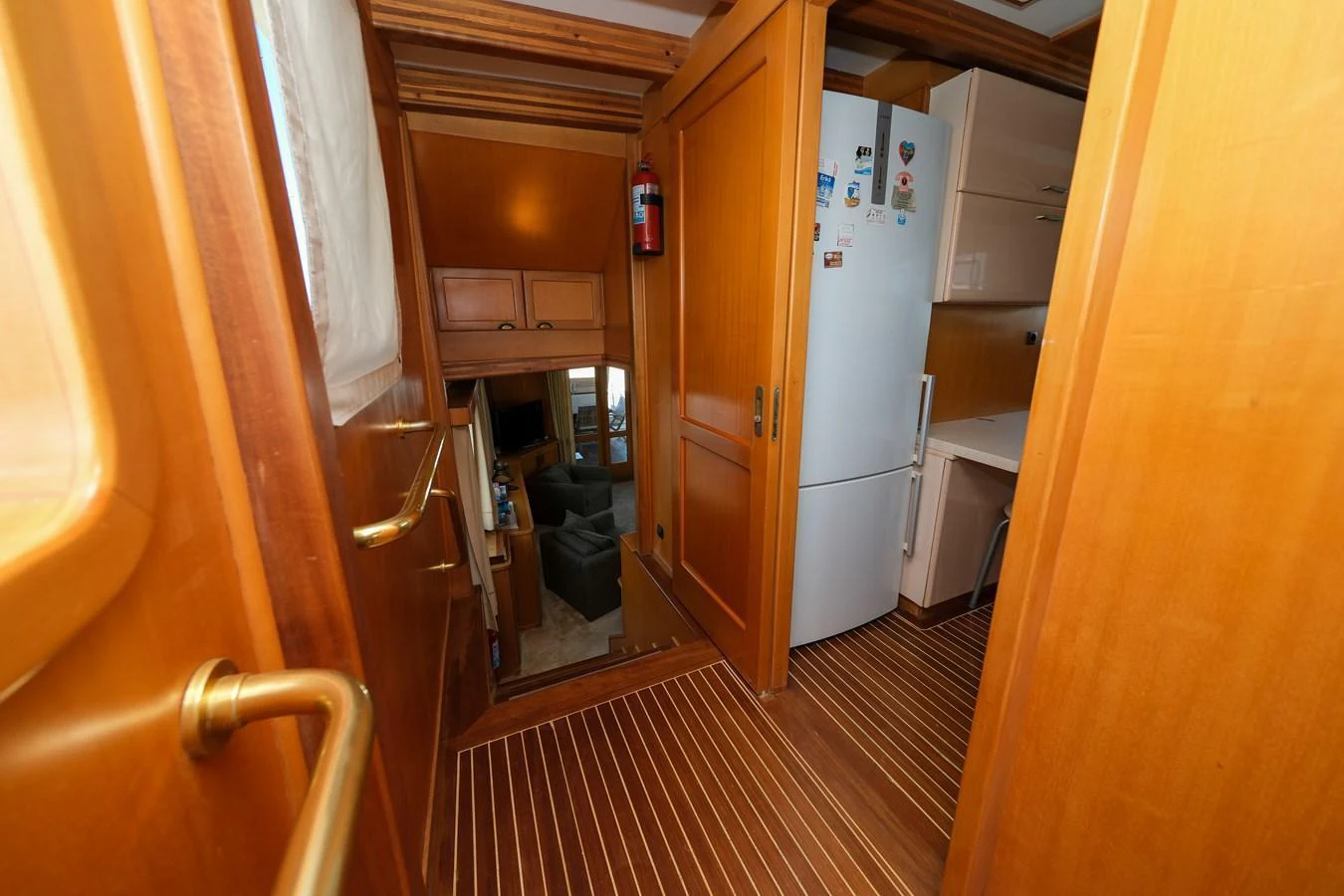 The image showcases a cozy galley area with wooden finishes and modern appliances. aboard XANAX Yacht for Sale