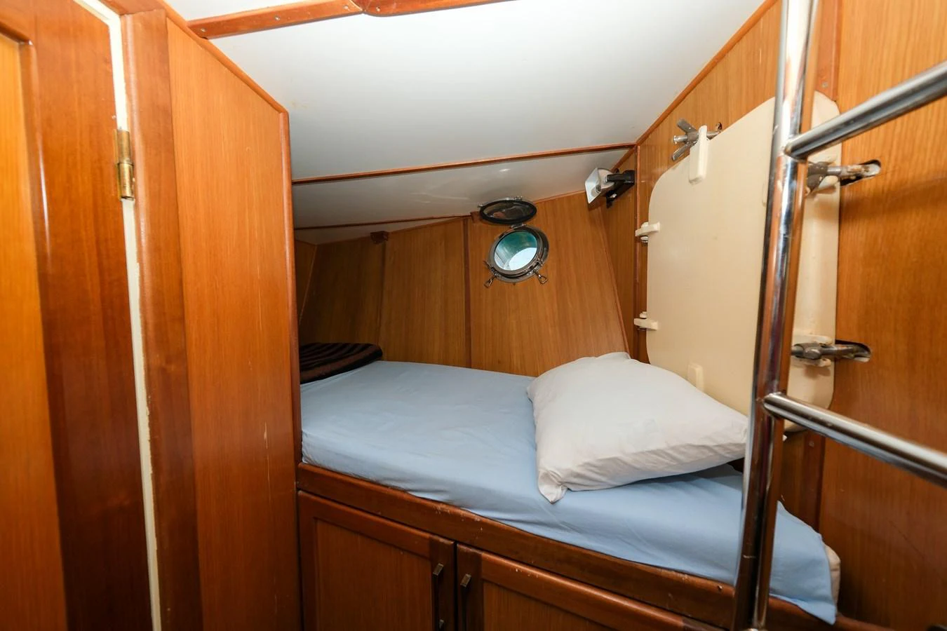 A cozy cabin with a single bed and wooden paneling. aboard XANAX Yacht for Sale