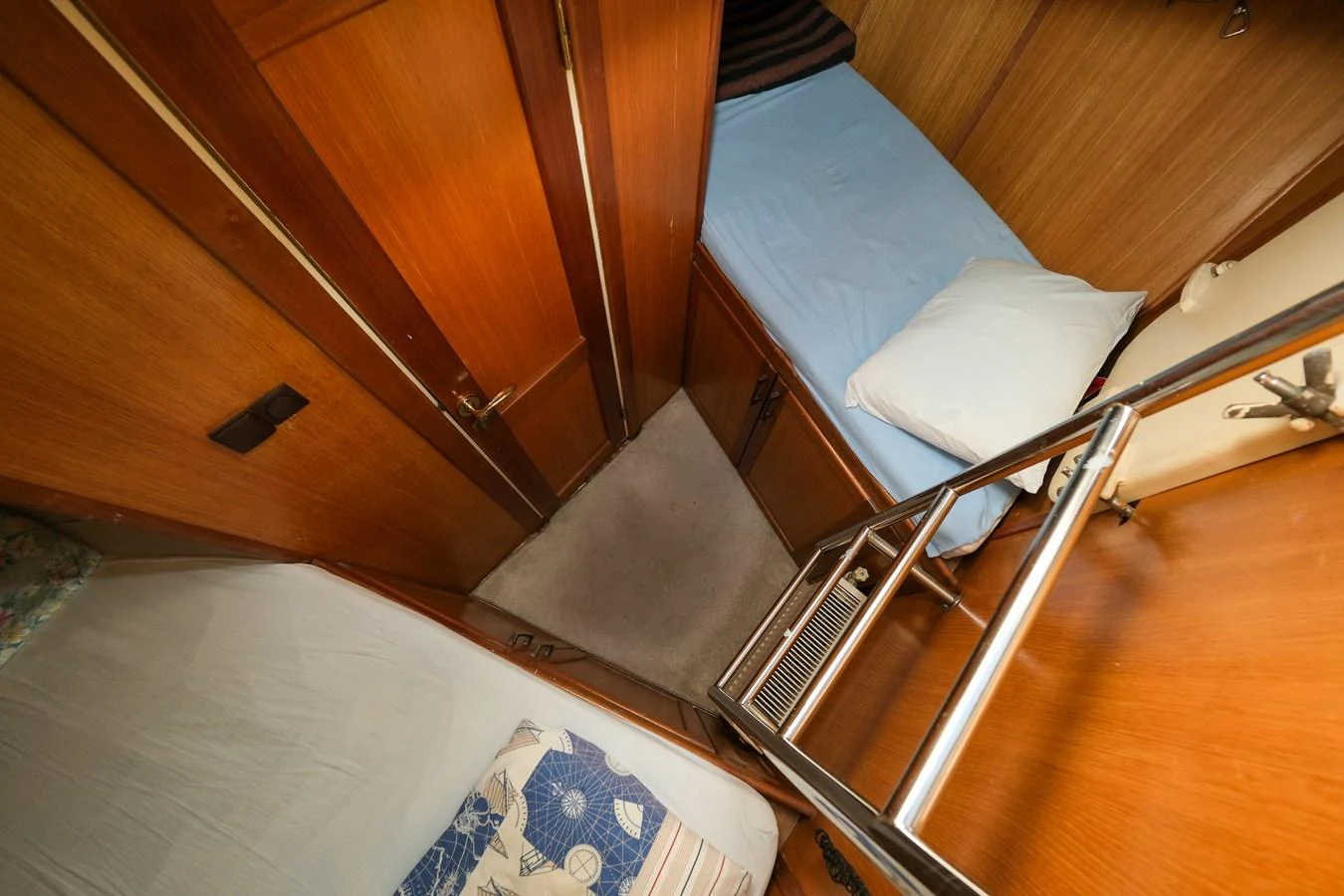 The cozy cabin features two single beds with wooden paneling and a compact layout. aboard XANAX Yacht for Sale