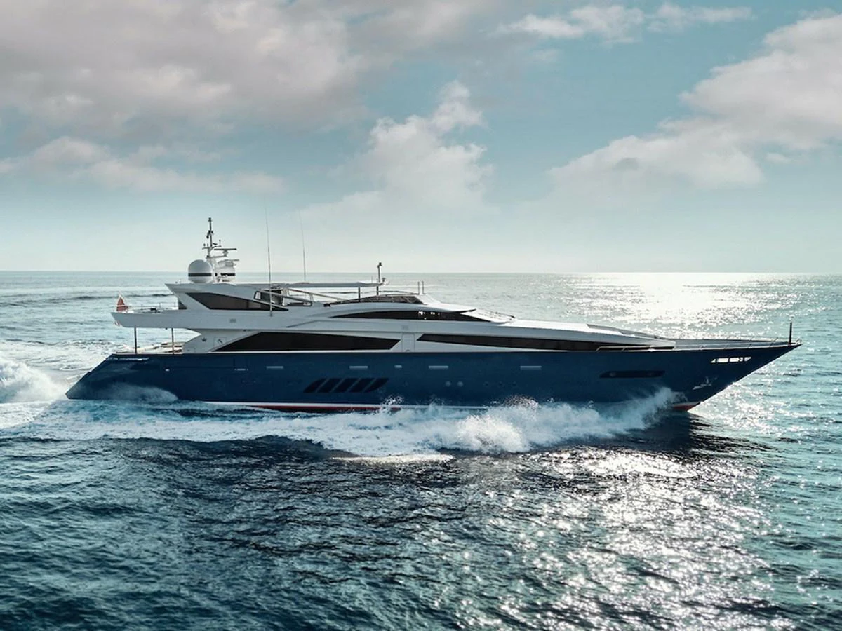 A sleek and modern yacht glides effortlessly through the open sea under a partly cloudy sky. aboard COF Yacht for Sale