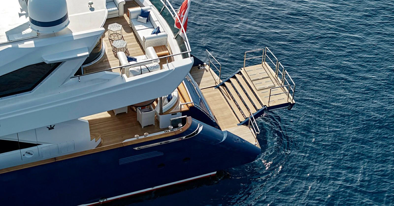 The yacht's aft deck features a luxurious lounging area with direct access to the water. aboard COF Yacht for Sale