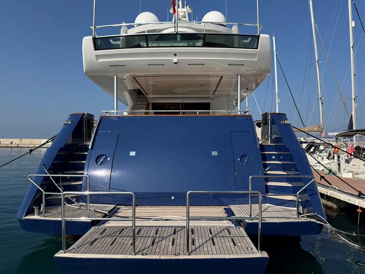 The yacht's aft deck features a spacious swim platform and elegant stairs leading up to the main deck. aboard COF Yacht for Sale
