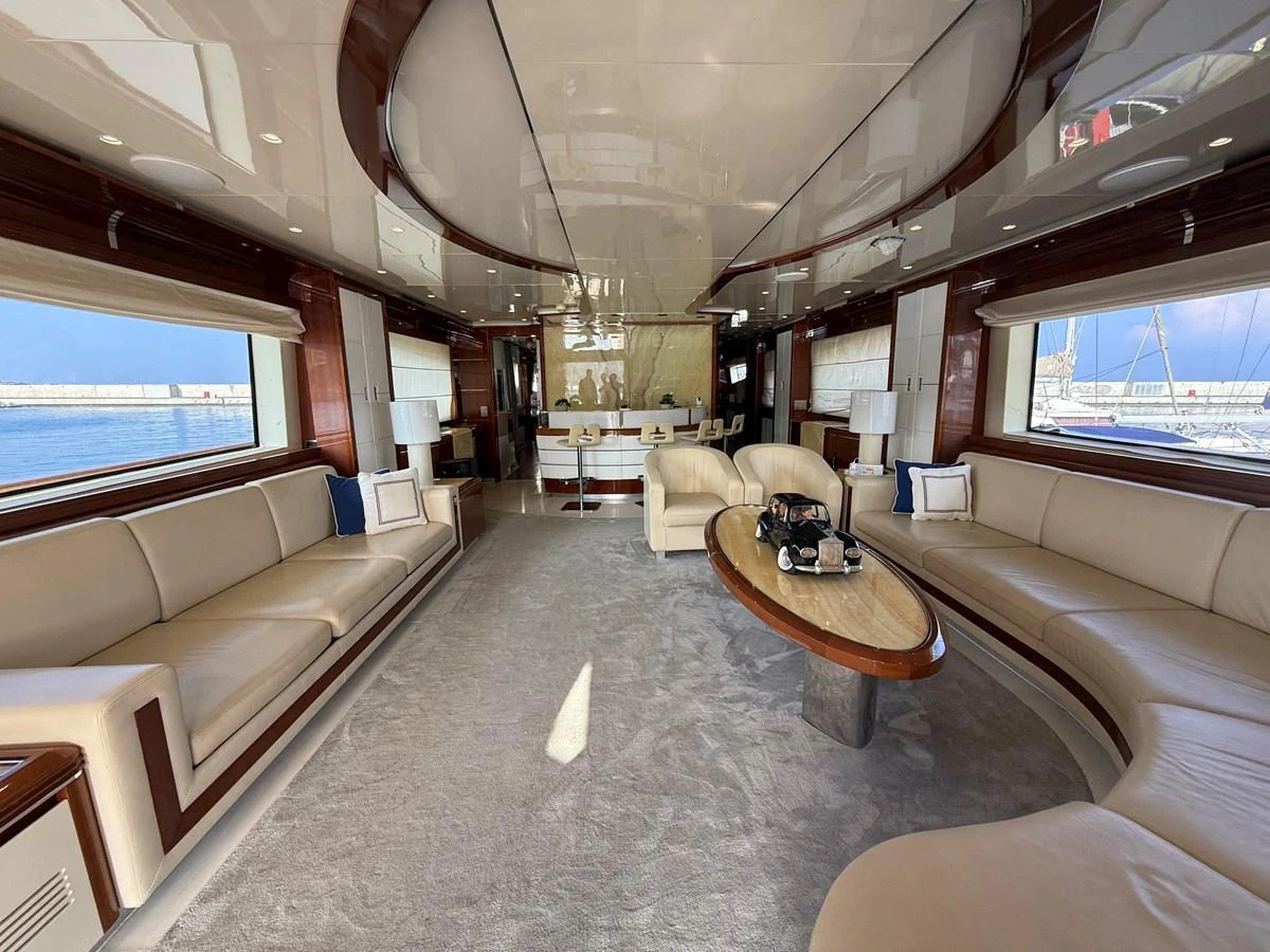 The spacious salon features elegant seating and a sophisticated design with large windows offering stunning views. aboard COF Yacht for Sale