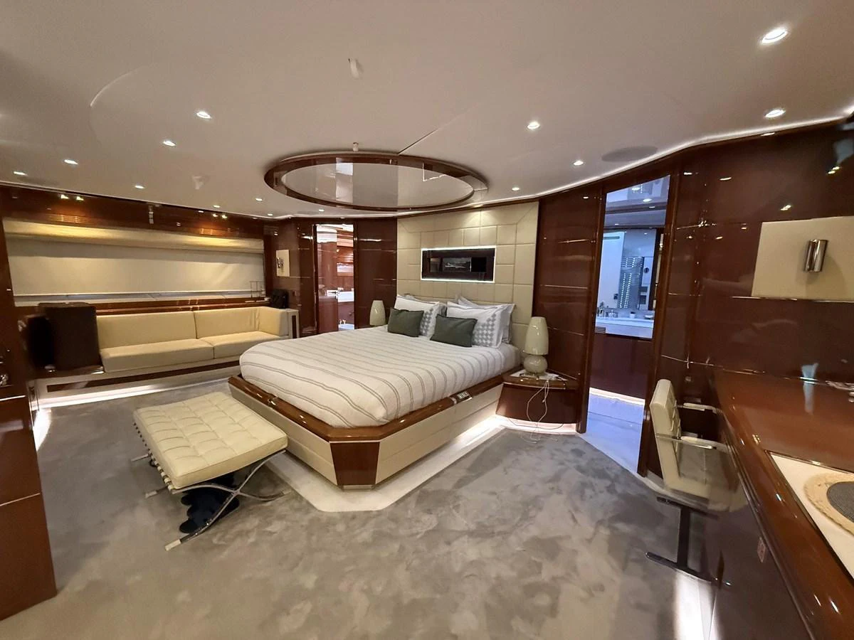 The master stateroom features a luxurious bed with elegant furnishings and ample lighting. aboard COF Yacht for Sale