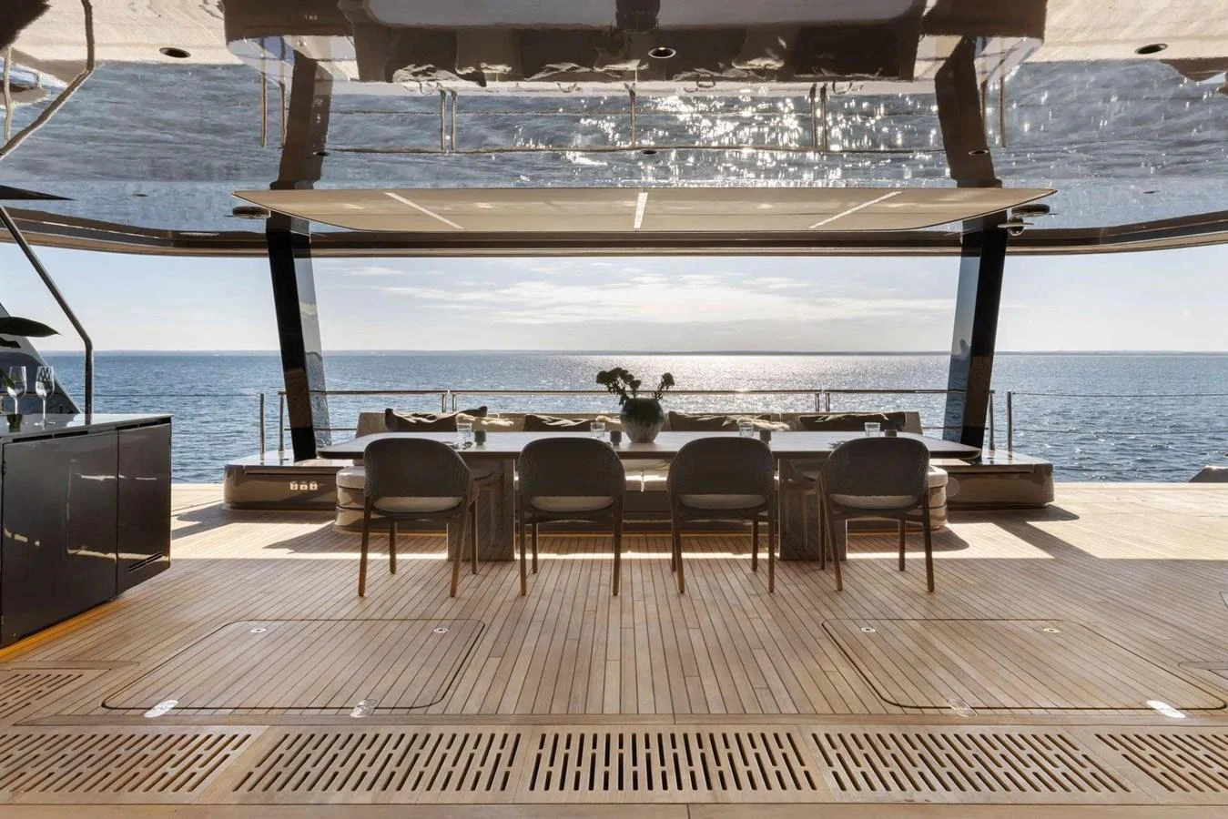 The aft deck offers a stunning view of the sea, featuring a spacious dining area with elegant seating. aboard TWILIGHT Yacht for Sale