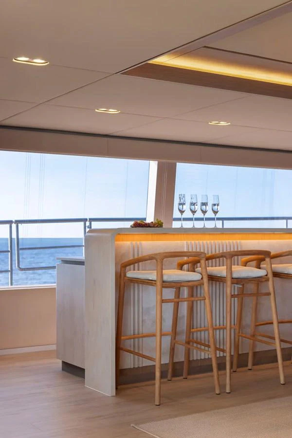 The yacht's interior features a stylish bar area with a view of the ocean. aboard TWILIGHT Yacht for Sale