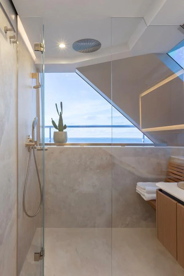 A modern yacht bathroom with a glass shower and ocean view. aboard TWILIGHT Yacht for Sale