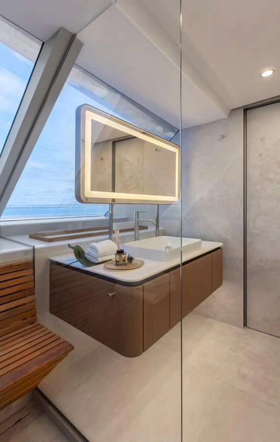 A modern yacht bathroom with a sleek vanity and large window offering a sea view. aboard TWILIGHT Yacht for Sale