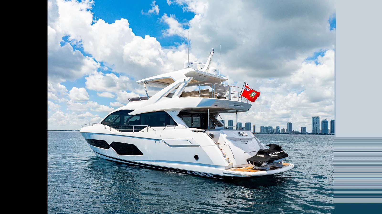 A sleek, modern yacht glides on calm waters with a city skyline in the background. aboard STEELN Yacht for Sale