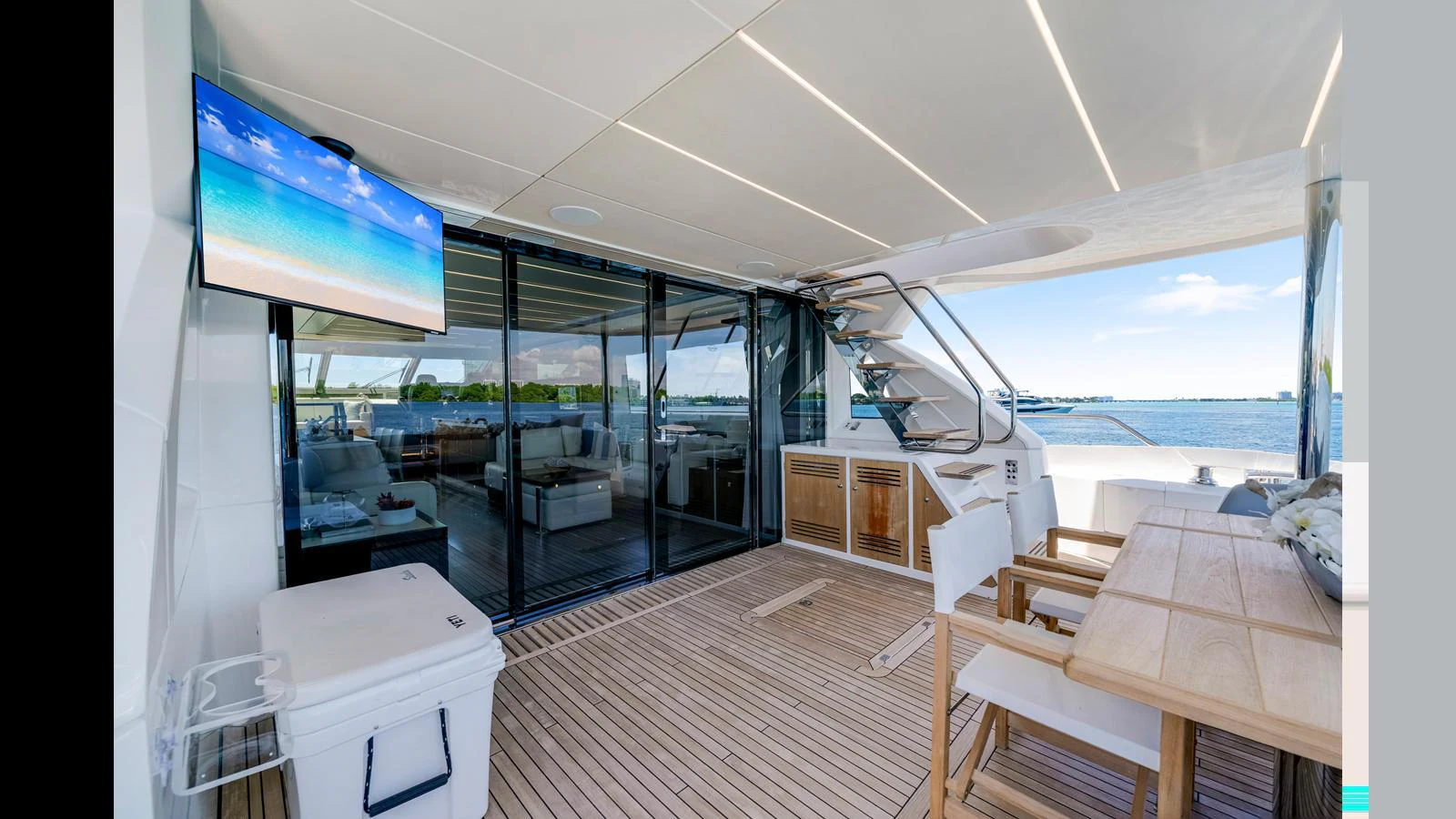 The aft deck features a comfortable seating area with a dining table and a view of the water. aboard STEELN Yacht for Sale