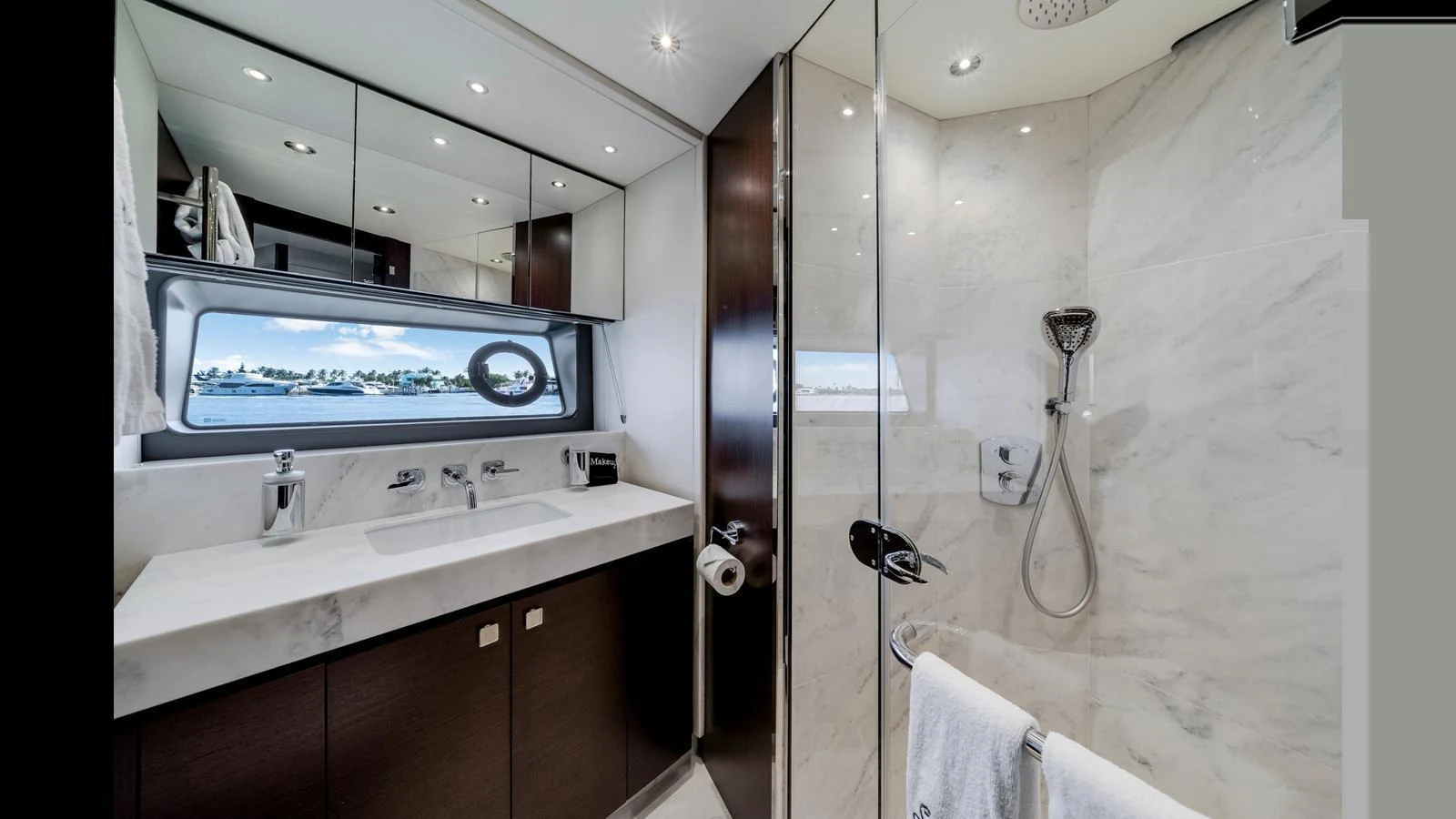 The yacht's bathroom features a sleek design with modern fixtures and a large window offering a view of the water. aboard STEELN Yacht for Sale