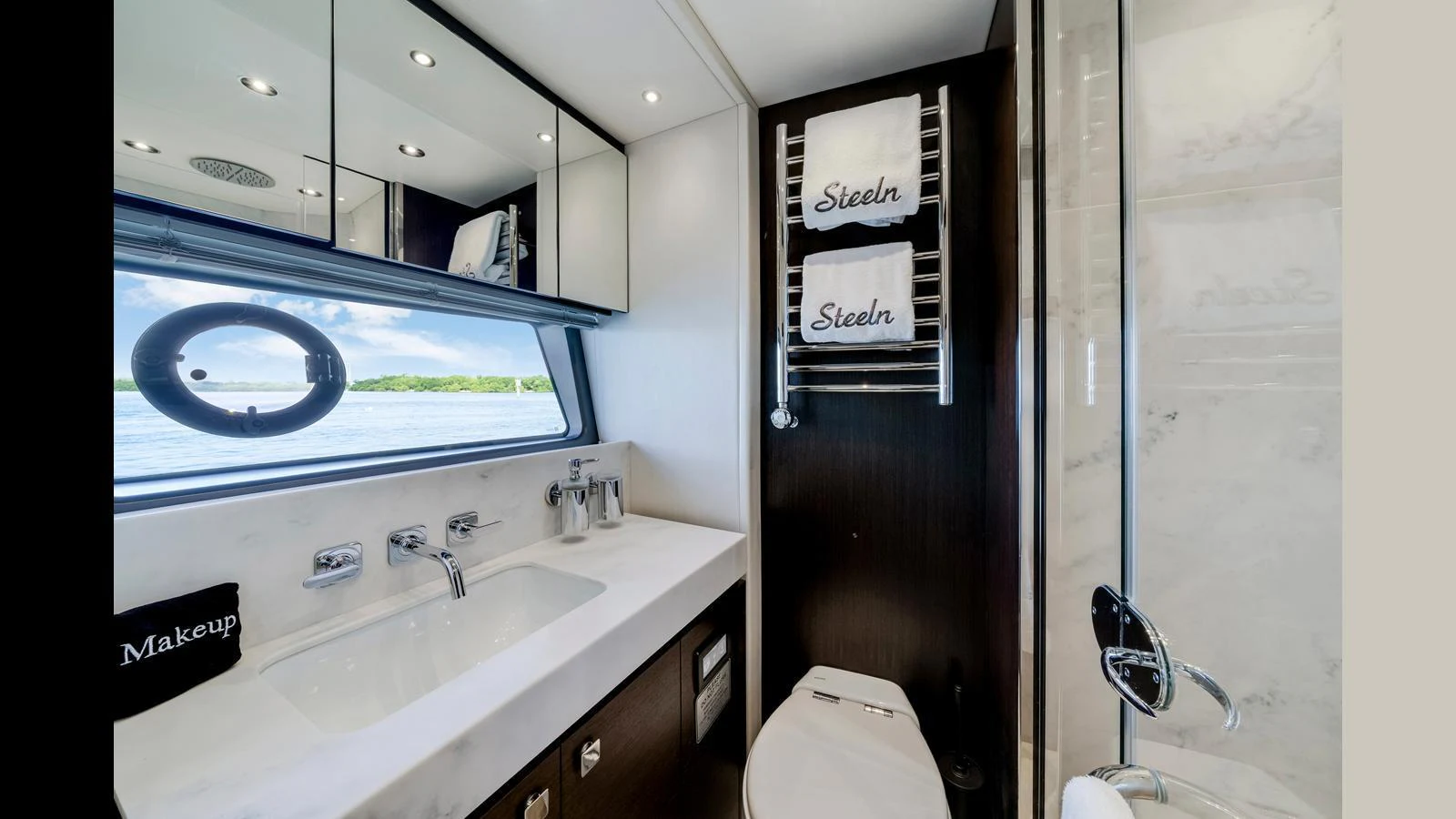 A sleek and modern yacht bathroom with a large window offering a view of the water. aboard STEELN Yacht for Sale