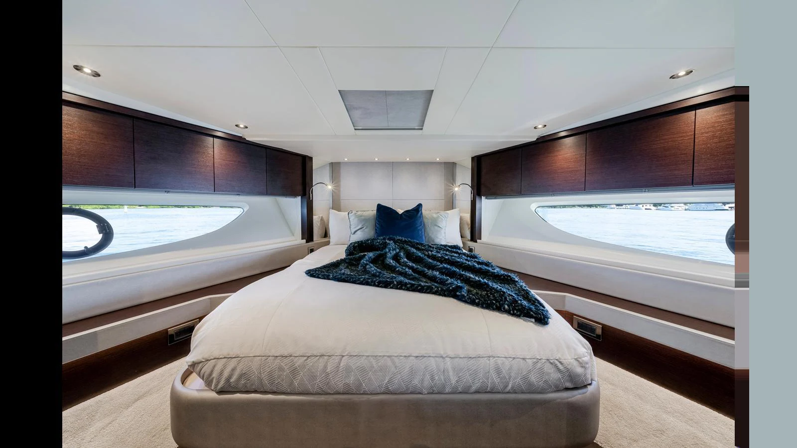 The master stateroom features a luxurious bed with elegant bedding and ample natural light from large windows. aboard STEELN Yacht for Sale