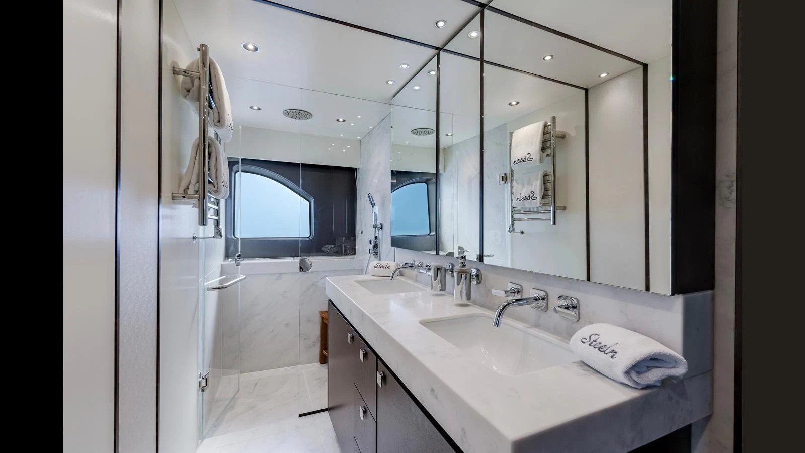 A luxurious yacht bathroom featuring dual sinks, a large mirror, and elegant fixtures. aboard STEELN Yacht for Sale