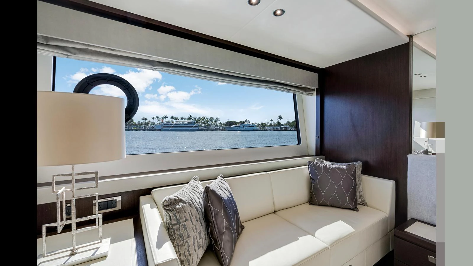 A luxurious seating area with a large window offering a scenic view of the water. aboard STEELN Yacht for Sale
