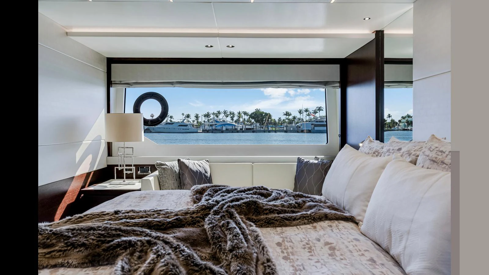 A luxurious stateroom with a large window offering a scenic view of the marina. aboard STEELN Yacht for Sale