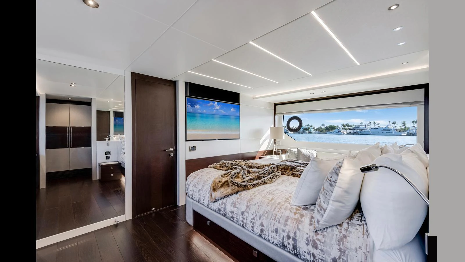 The master stateroom features a luxurious bed with a scenic view through large windows. aboard STEELN Yacht for Sale