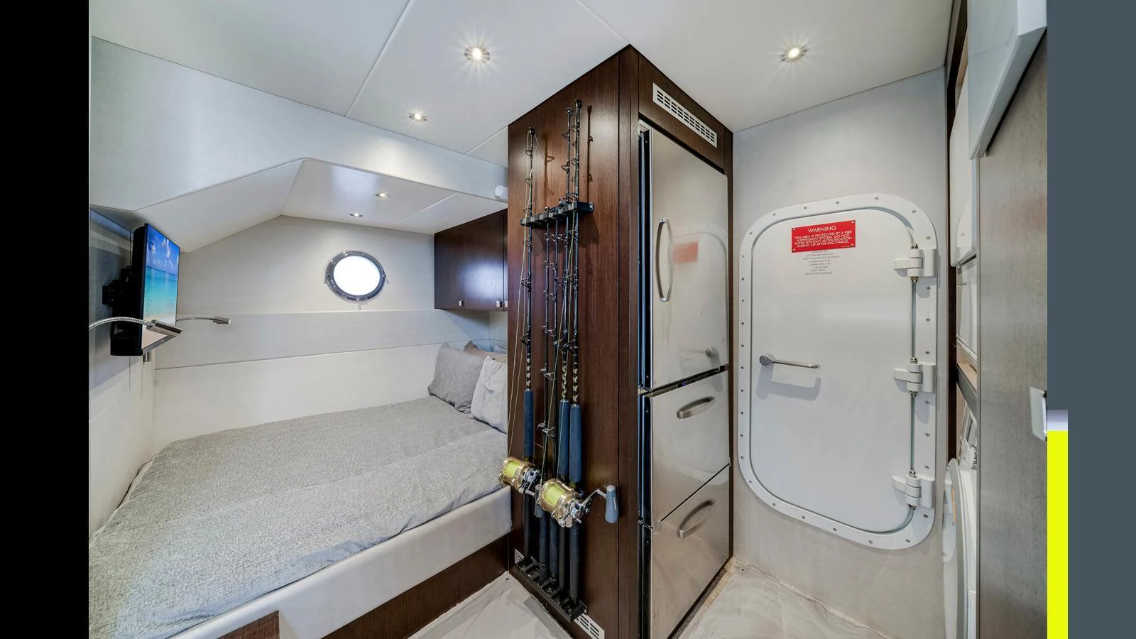 A cozy cabin featuring a comfortable bed, fishing rods, and a secure door. aboard STEELN Yacht for Sale
