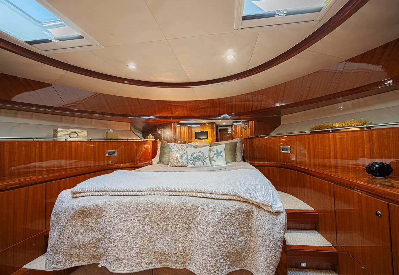 The stateroom features a luxurious bed with elegant wood paneling and ample natural light from overhead skylights. aboard MARGARITA Yacht for Sale