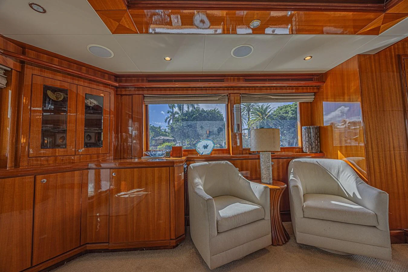 The yacht's interior features a cozy seating area with two plush armchairs and elegant wooden cabinetry. aboard MARGARITA Yacht for Sale