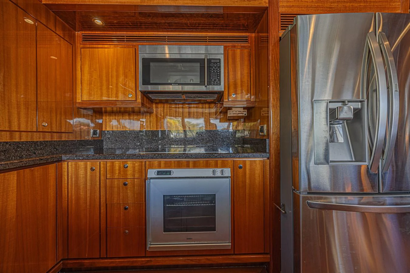 The yacht's galley features sleek wooden cabinetry, modern appliances, and a polished granite countertop. aboard MARGARITA Yacht for Sale