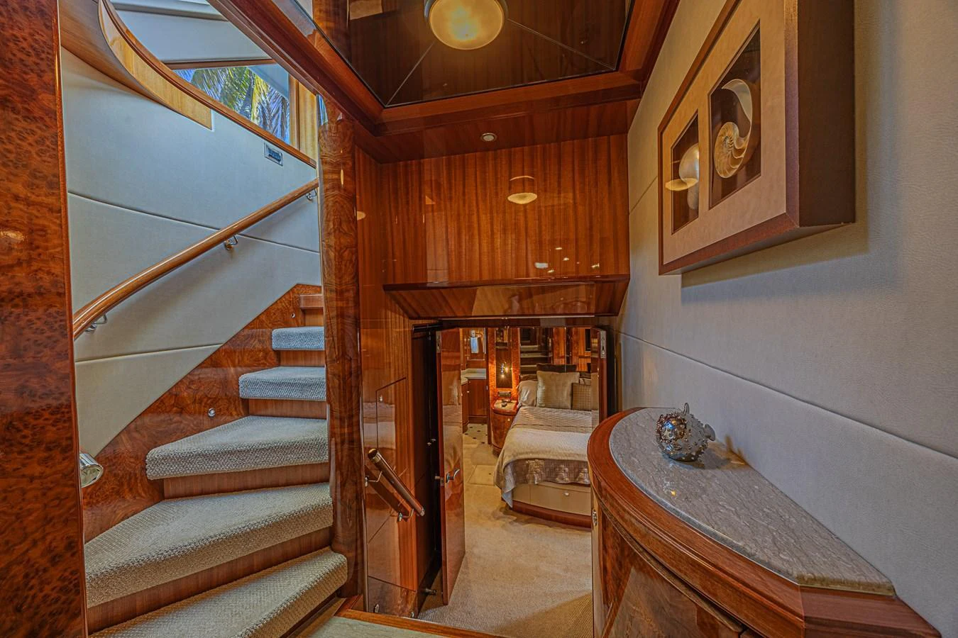 The image showcases a luxurious yacht interior with a beautifully designed staircase leading to a cozy stateroom. aboard MARGARITA Yacht for Sale