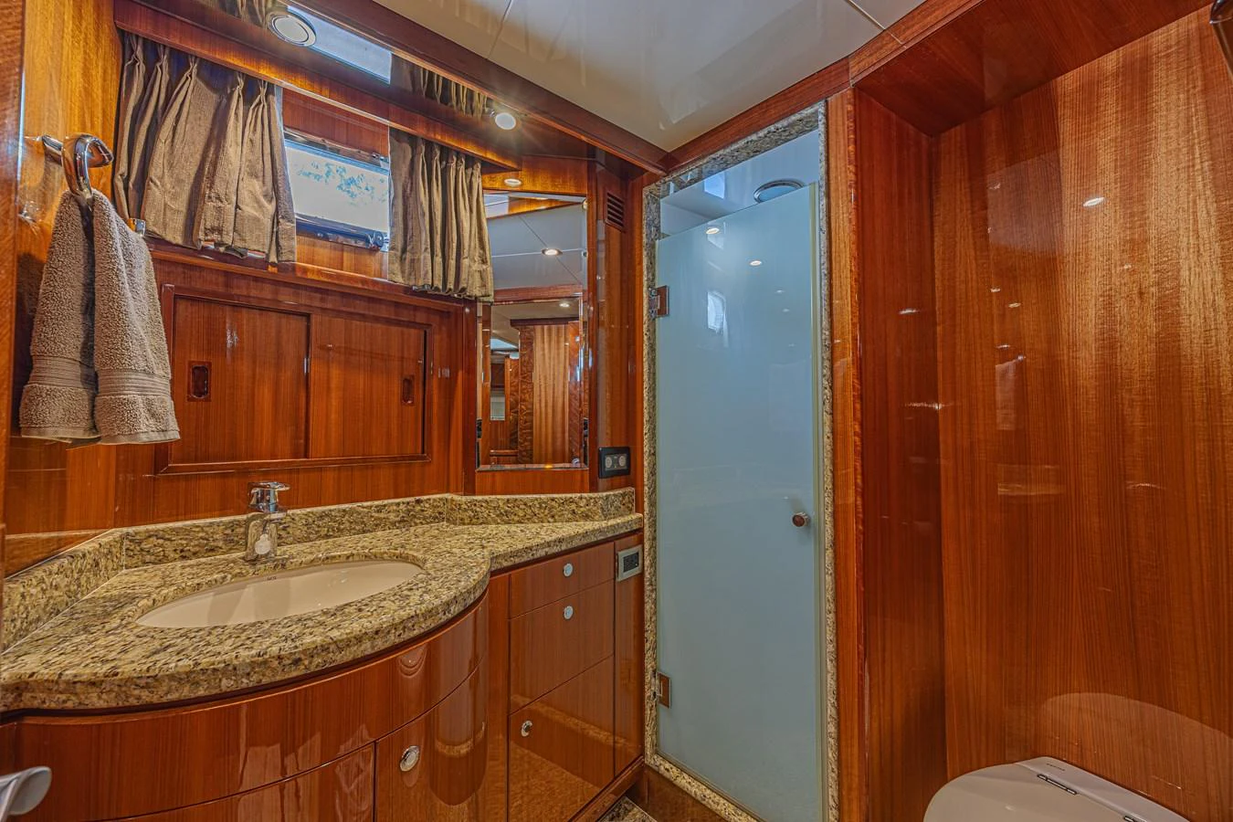 The yacht's bathroom features elegant wood paneling and a granite countertop, creating a luxurious and warm ambiance. aboard MARGARITA Yacht for Sale