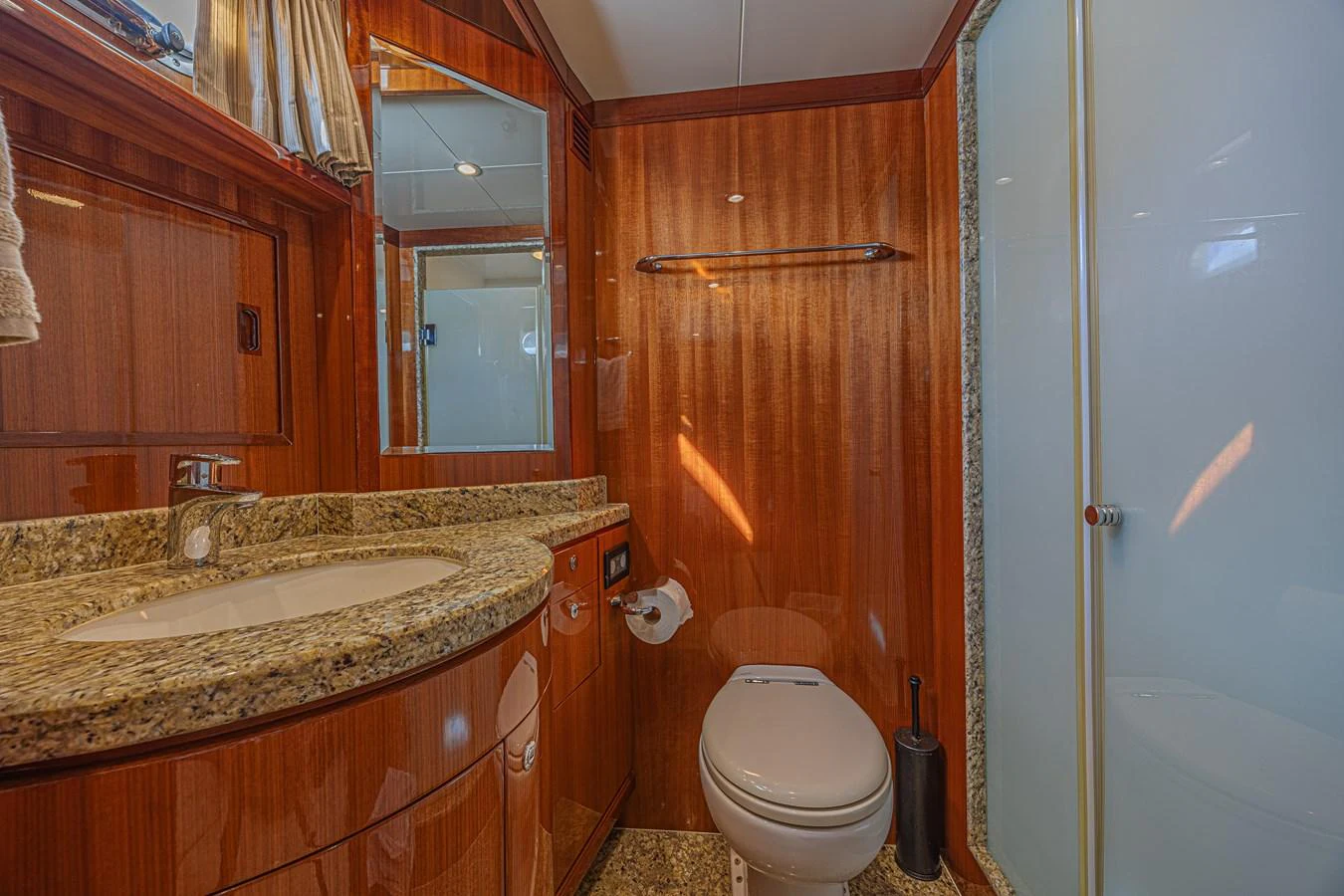 The yacht's bathroom features elegant wood paneling and a granite countertop. aboard MARGARITA Yacht for Sale