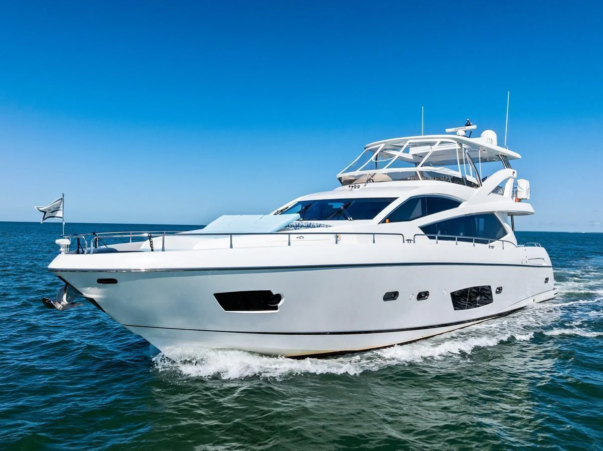 A sleek and modern yacht cruises smoothly on the open water under a clear blue sky. aboard IT'S ENOUGH Yacht for Sale