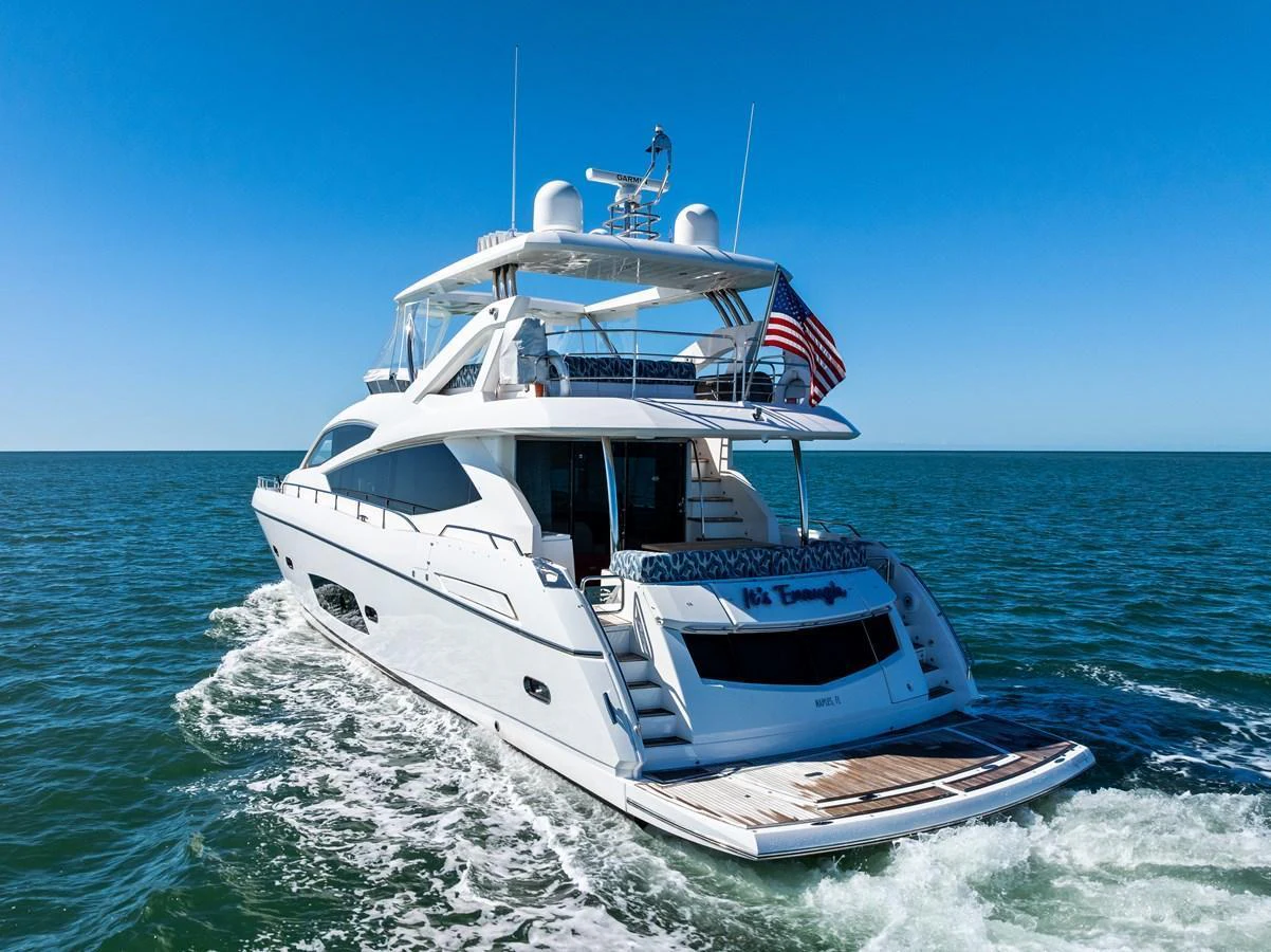 A luxurious yacht cruising on open waters under a clear blue sky. aboard IT'S ENOUGH Yacht for Sale