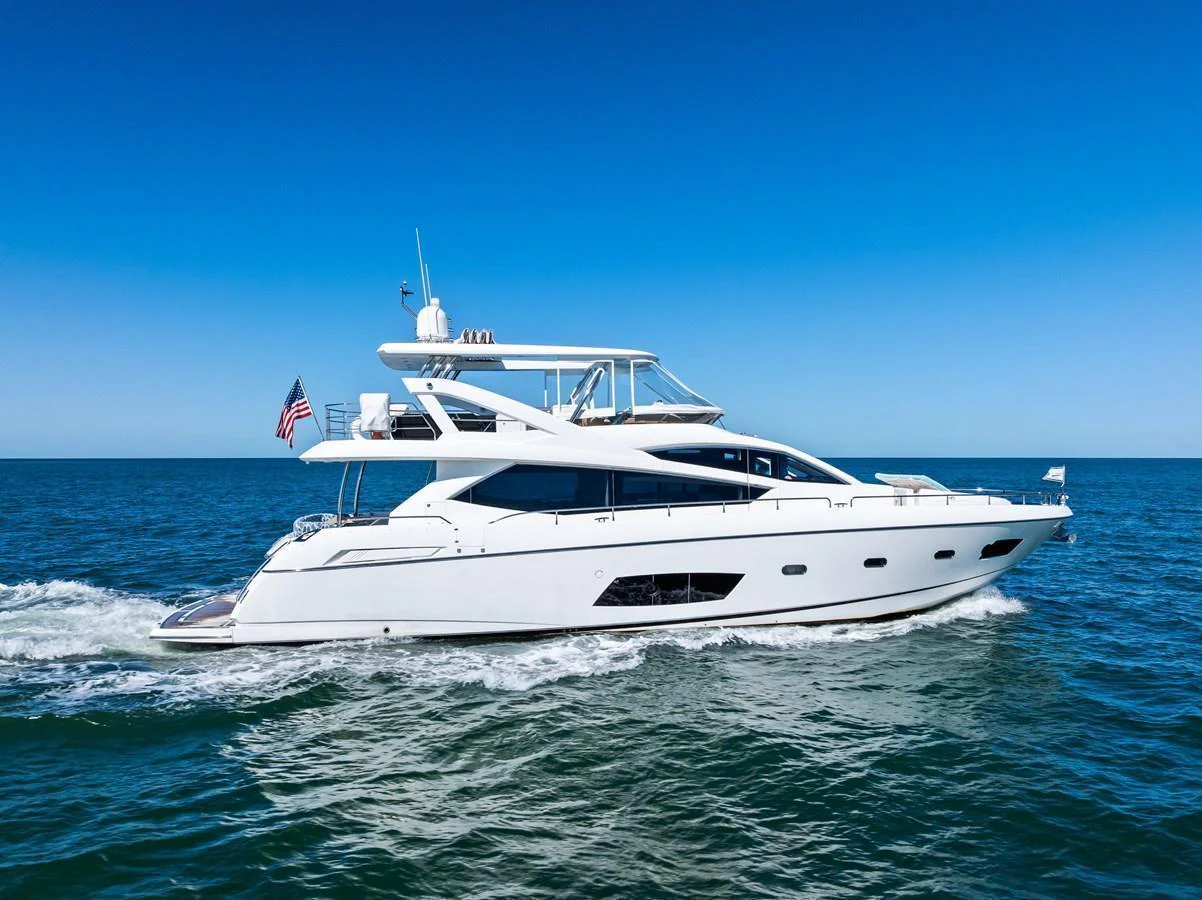 A sleek white yacht cruises through the open sea under a clear blue sky. aboard IT'S ENOUGH Yacht for Sale
